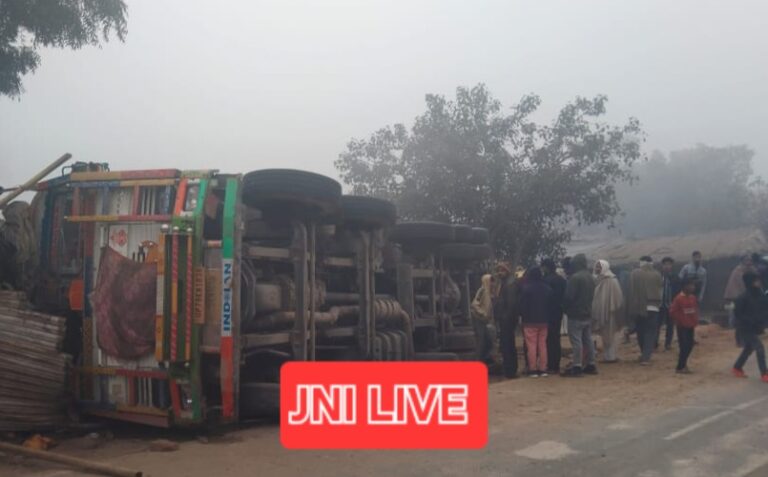 ड्राइवर को झपकी आने से धान भरा ट्रक पलटा, आधा दर्जन दुकानों के खोखे क्षतिग्रस्त